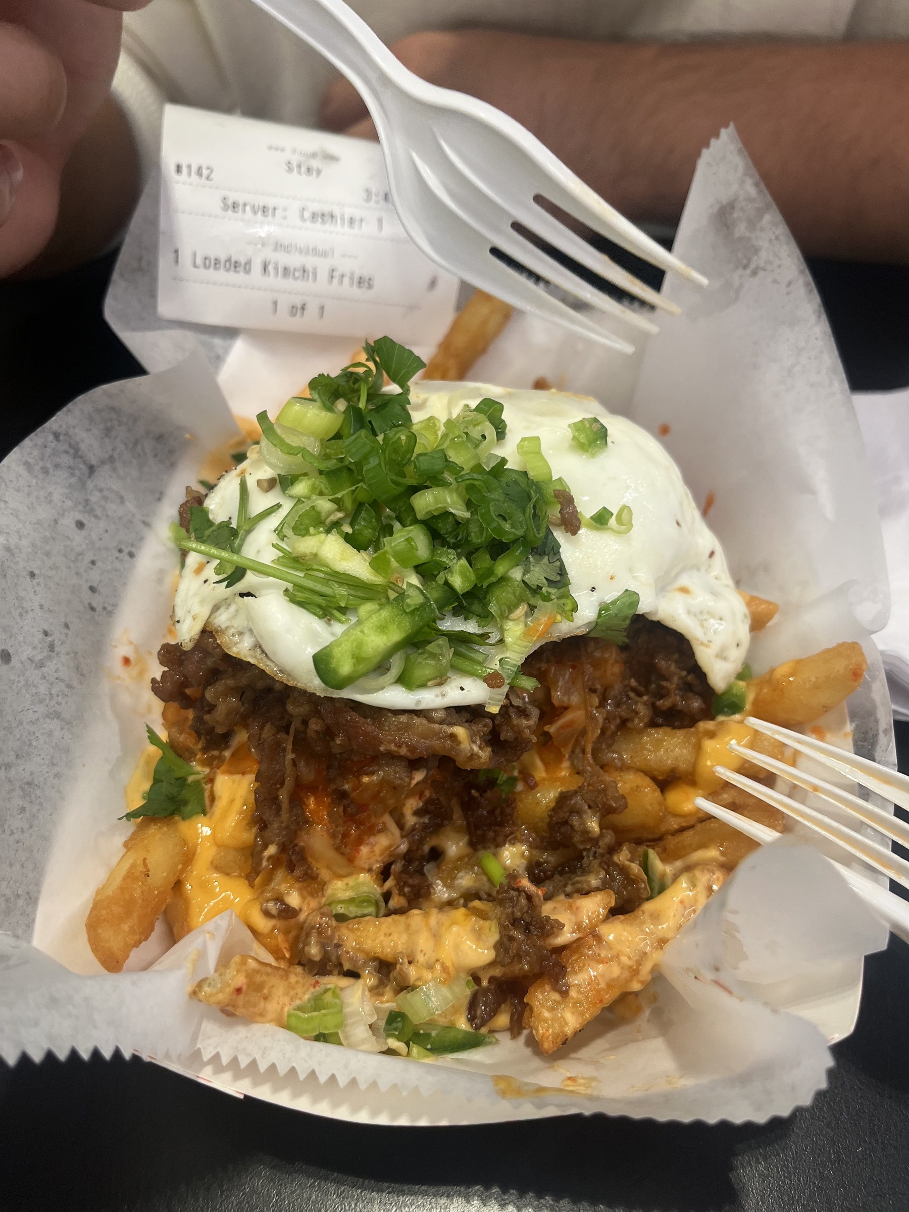 Loaded kimchi fries topped with egg and green onions