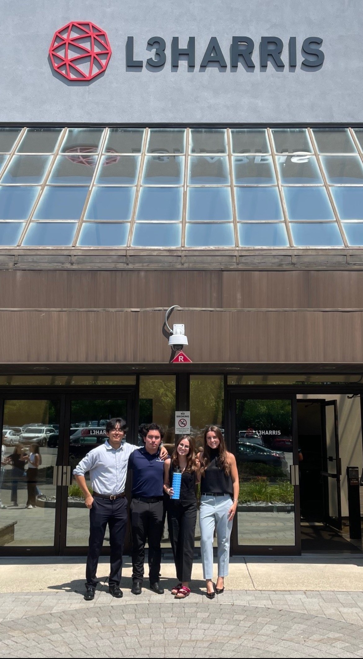 Four L3Harris project teammates outside the office